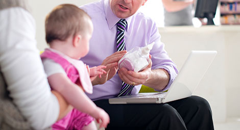 A male doctor speaking with a woman and her baby